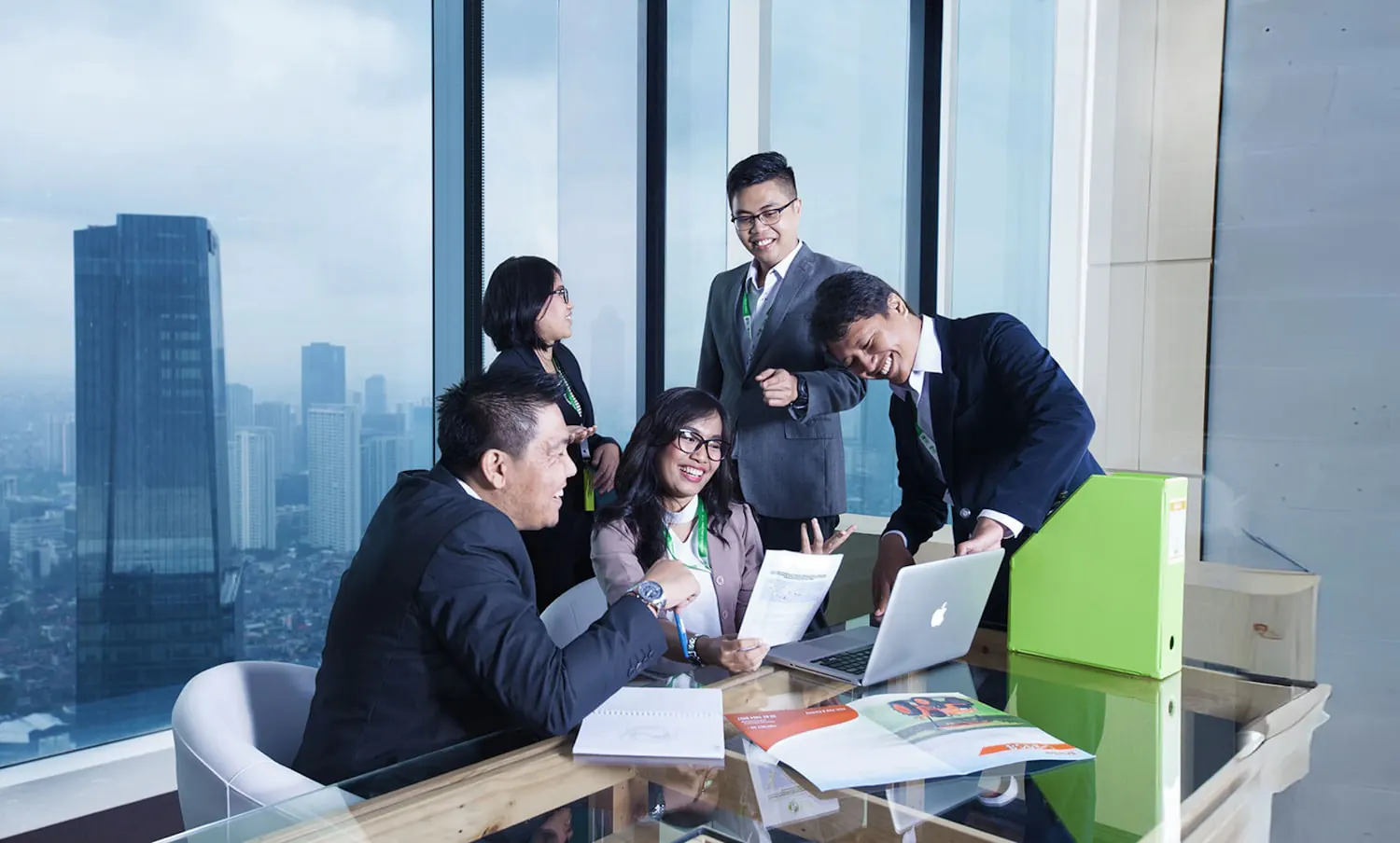 Business professionals meeting in a high-rise office with a city skyline view.